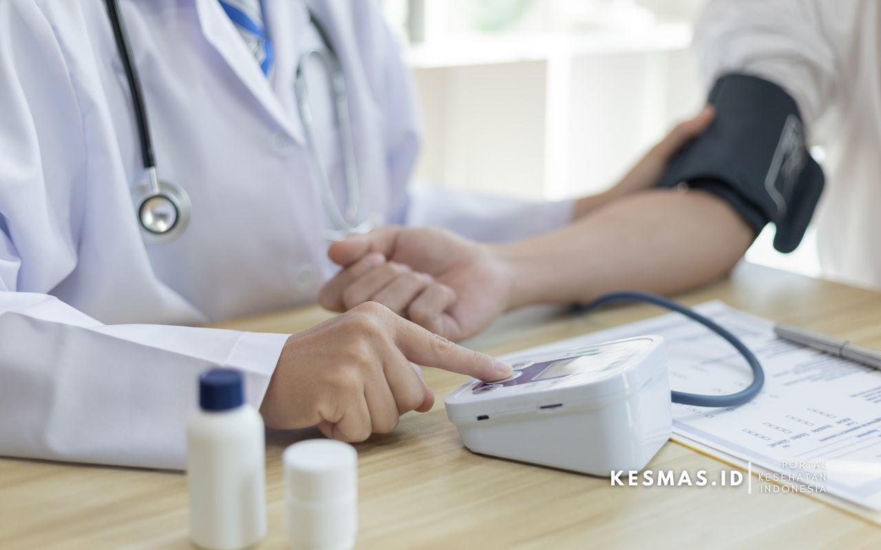 dokter memeriksa tekanan darah pasien menggunakan alat tensi digital