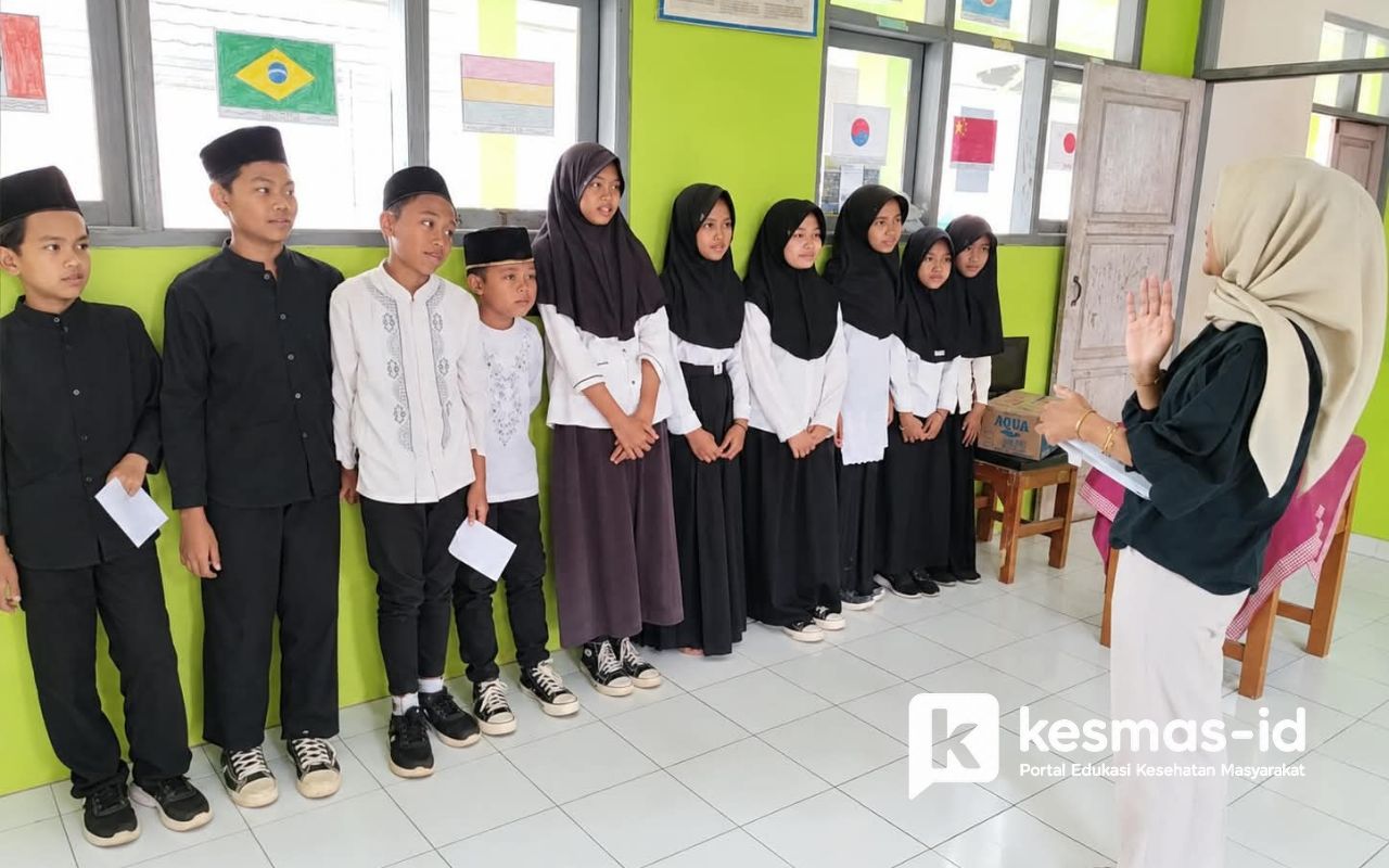 Siswa mengikuti arahan petugas dalam kegiatan POPM Kecacingan di lingkungan sekolah.